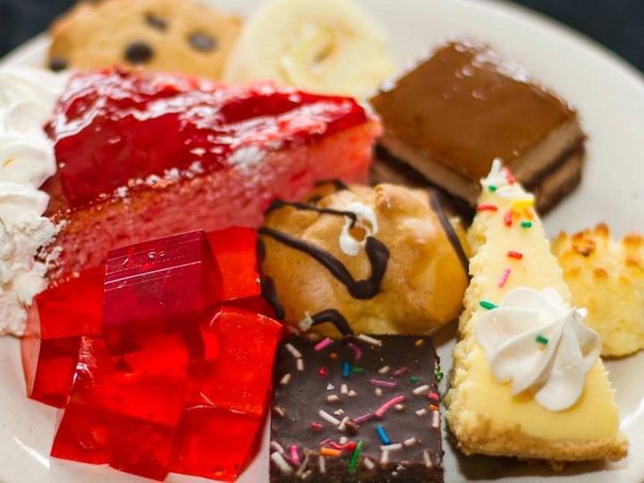 A dessert plate with cake, jello, cookies and cream puffs